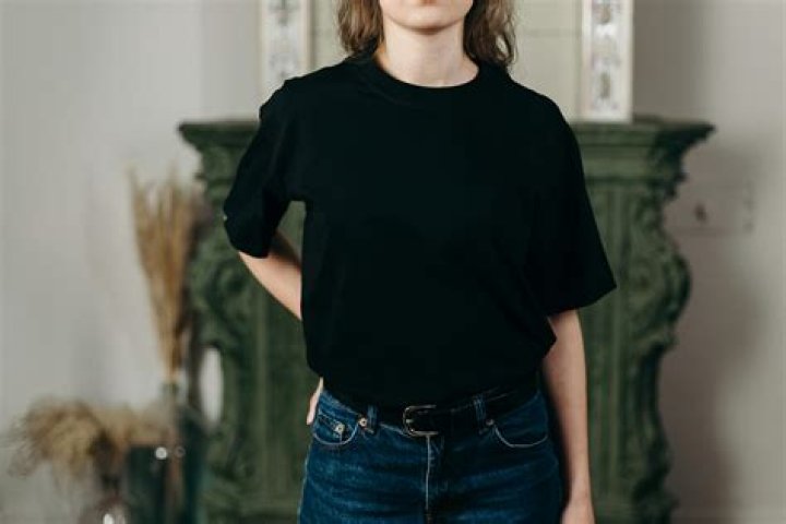 a person wearing a black shirt and gold necklaces a person wearing a black shirt and gold necklaces