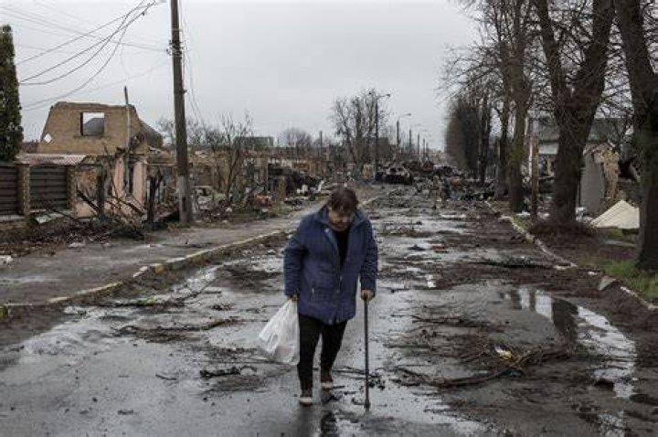 A Ukrainian woman walks amid the debris of a residential building following night shelling in Mykolaiv, Ukraine, Tuesday, Aug. 2, 2022. 