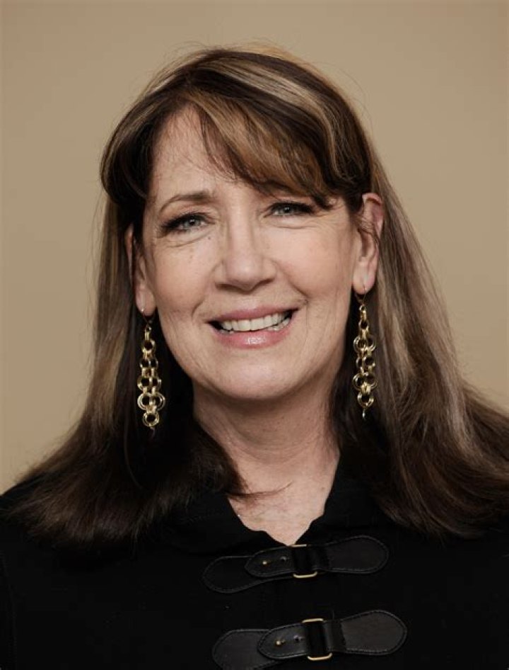 Ann Dowd smiling in front of a white background