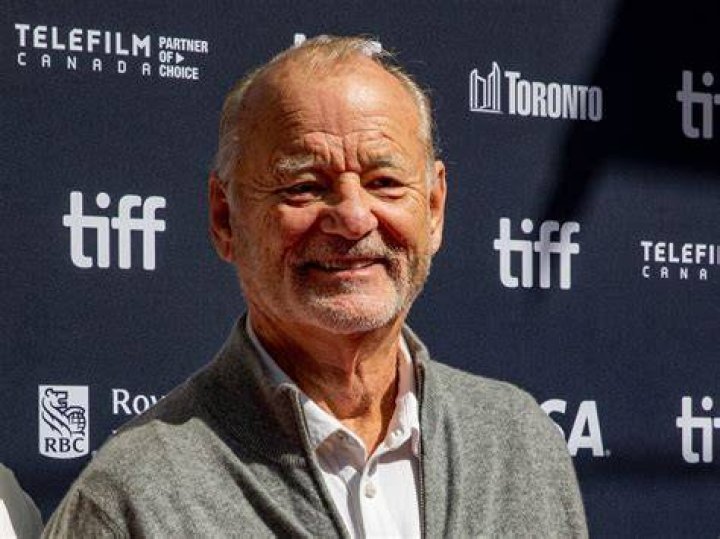 Bill Murray, who was a part of the 'Scrooged' cast, wears a light gray tweed suit over a dark blue button-up shirt and light yellow tie.