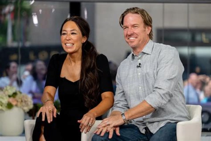 Chip and Joanna Gaines sit next to each other and smile.