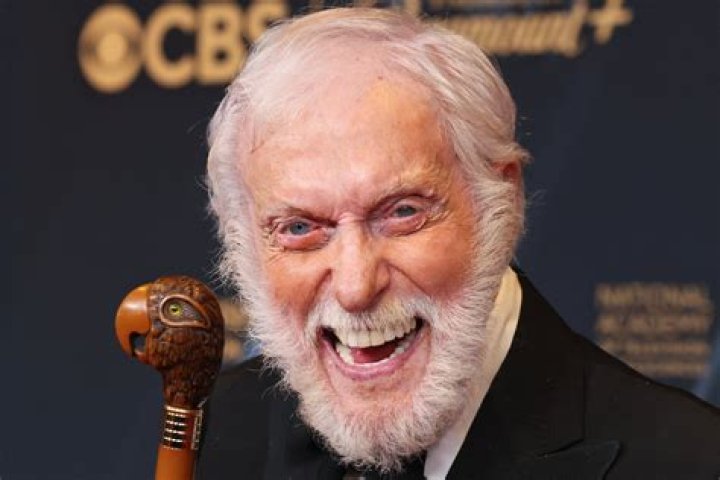 Dick Van Dyke smiles while outside and surrounded by people