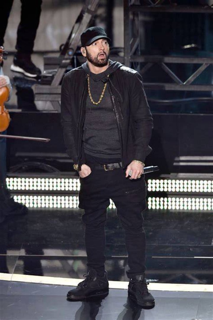 Eminem dressed in a black cap and jacket speaking at Curtis '50 Cent' Jackson's star ceremony on the Hollywood Walk of Fame