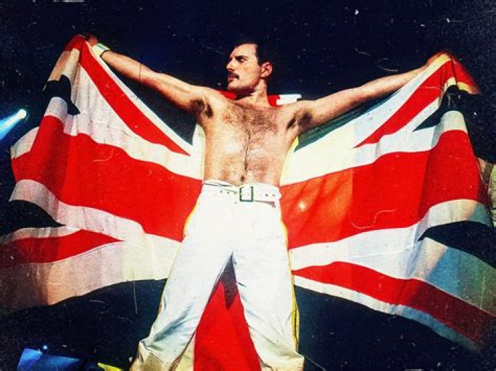 Freddie Mercury, the singer behind many classic rock songs, raising his arm