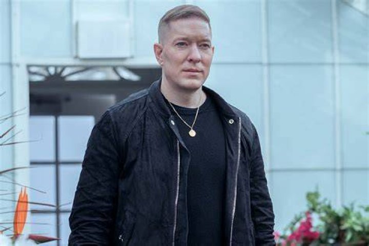 Joseph Sikora wearing a black shirt and gold chain
