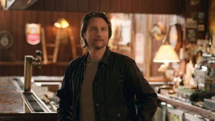 Martin Henderson as Jack Sheridan looking worried on the phone Alexandra Breckenridge as Mel Monroe listening in the background in 'Virgin River'