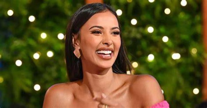 Maya Jama host of 'Love Island' poses on the red carpet in a black dress.