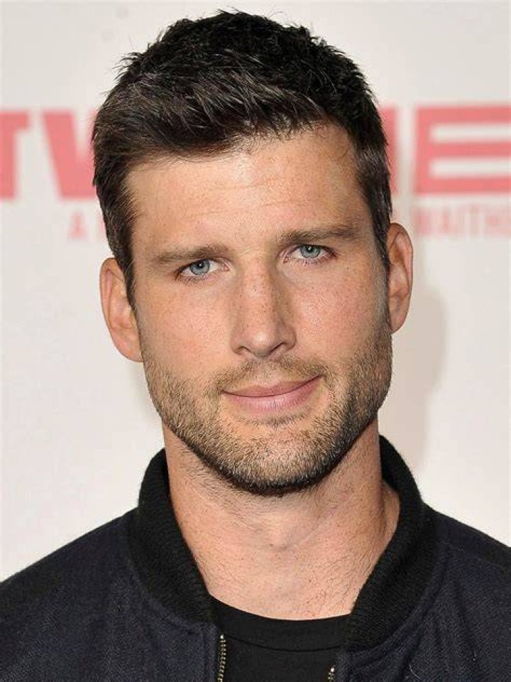 Parker Young in a blue shirt and jeans, and Adhir Kalyan in a plaid shirt and jeans in a scene from 'United States of Al.'