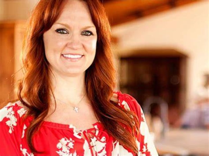 Ree Drummond smiles and looks on wearing a pink top