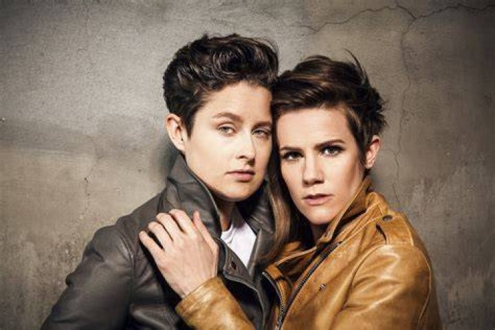 Rhea Butcher stands while holding a microphone