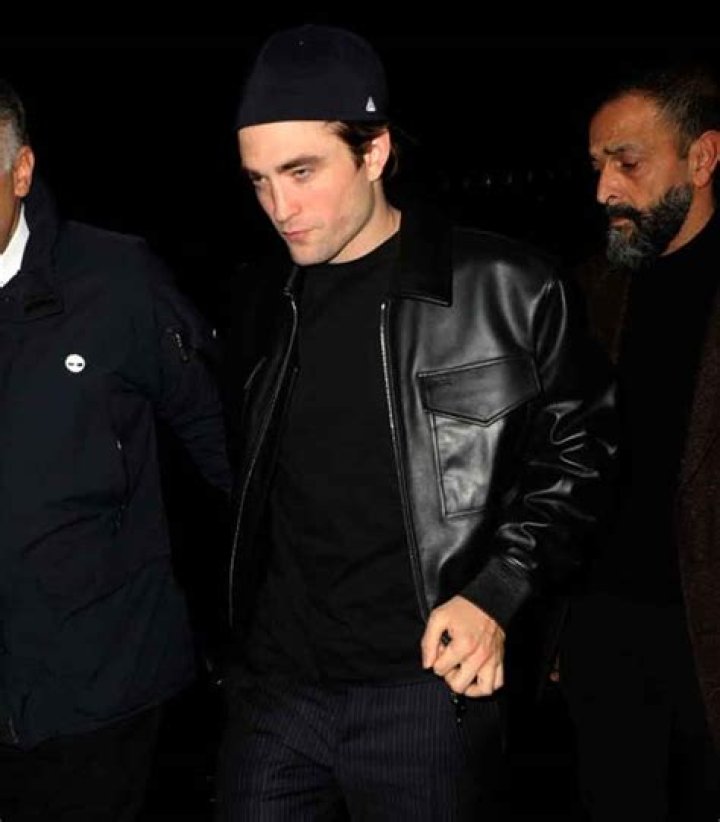 Robert Pattinson wears black and poses on the red carpet