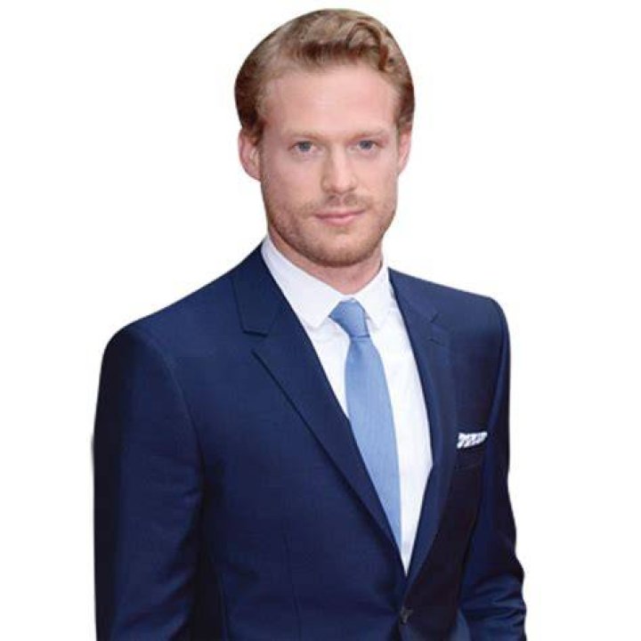 Sam Reid in a blue shirt and gray jacket at the 'Girl from the North Country' afterparty