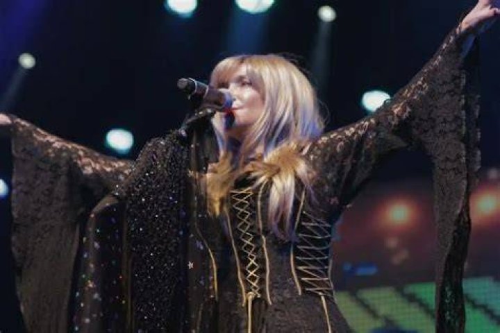 Stevie Nicks sings into a microphone.
